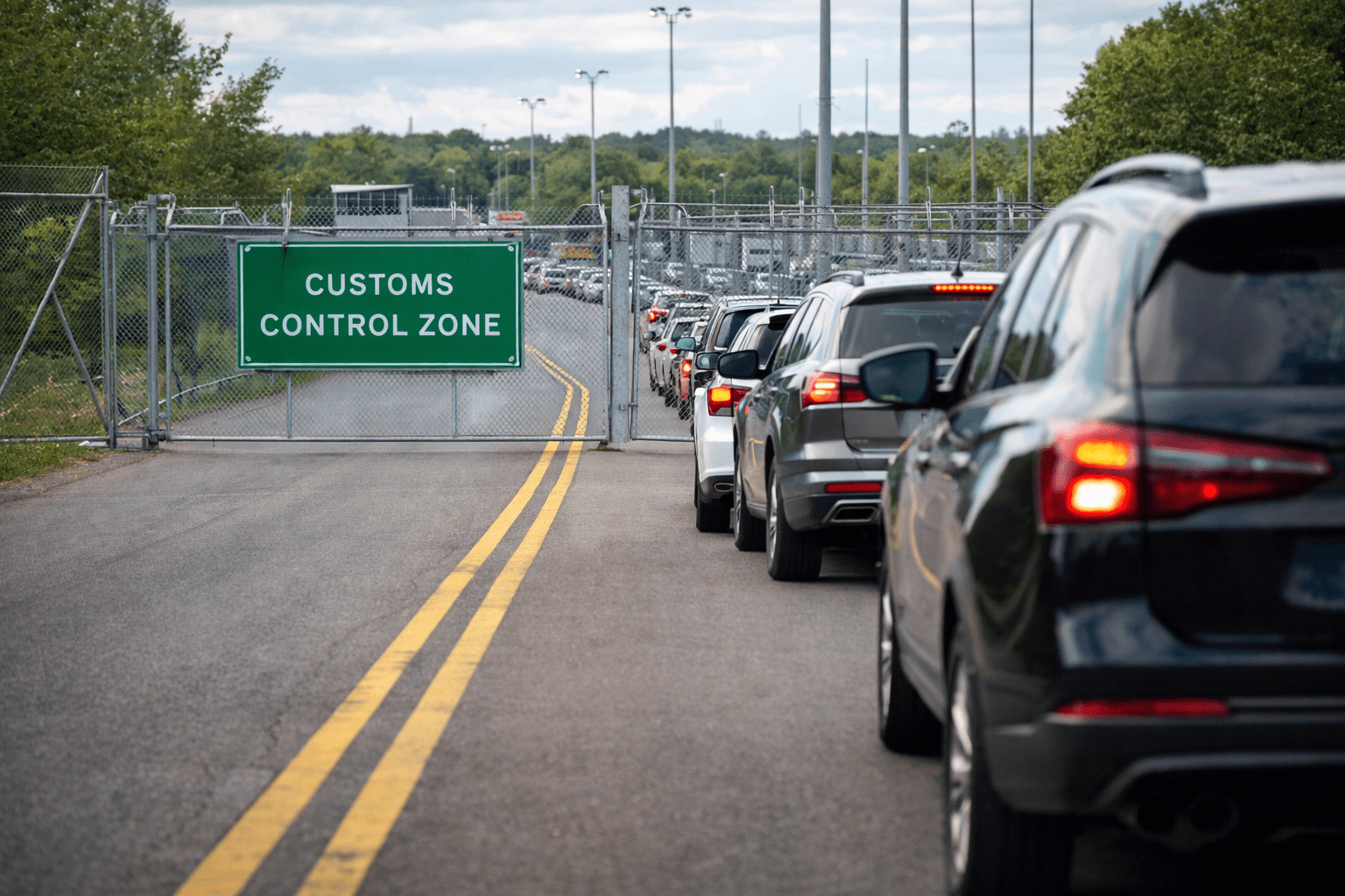 Line of cars leading to gated Customs control zone of Canada